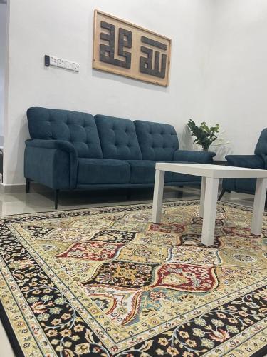 a living room with a blue couch and a table at Qayyum Homestay Pauh Lima,Bachok,Kelantan in Bachok