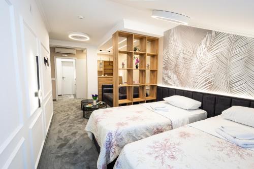 a room with two beds and a wall mural at Garni Hotel Lotos in Niš