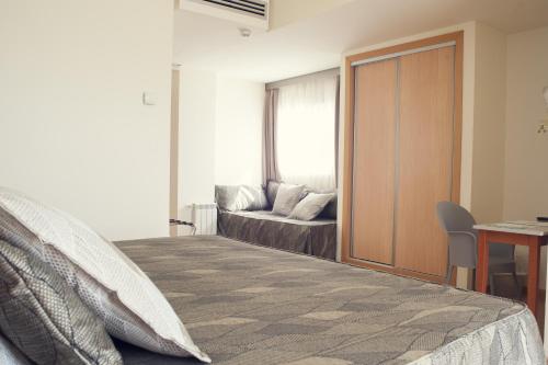 Schlafzimmer mit einem Bett, einem Schreibtisch und einem Fenster in der Unterkunft Hotel Oasis Plaza in Benidorm