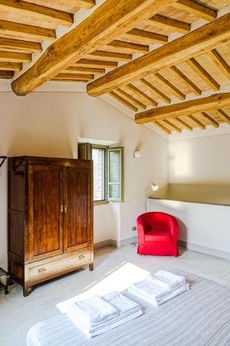 a bedroom with a bed and a red chair at Agriturismo Montelovesco in Brunetta