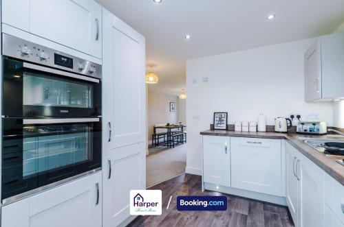 a kitchen with white cabinets and a black oven at Spacious 5BR Contractor Stay Sleeps 10 in Chester in Hough Green