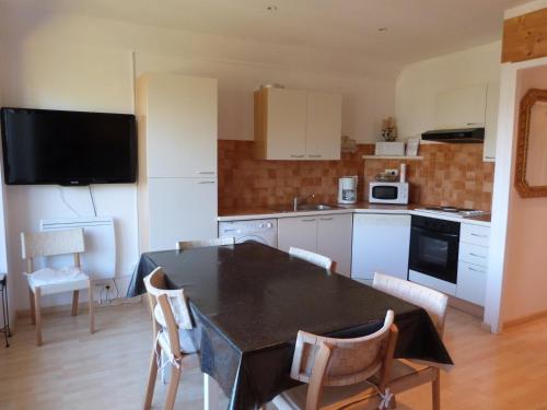 une cuisine avec une table et des chaises dans une cuisine dans l'établissement Appartement le Gray d'albion Praloup, à Uvernet
