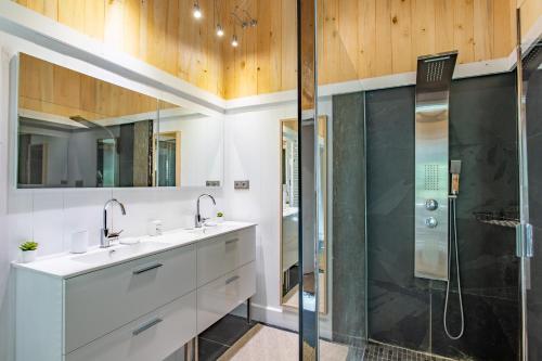 a bathroom with two sinks and a shower at Magnifique Villa avec jacuzzi les 44Hectares in Cap-Ferret