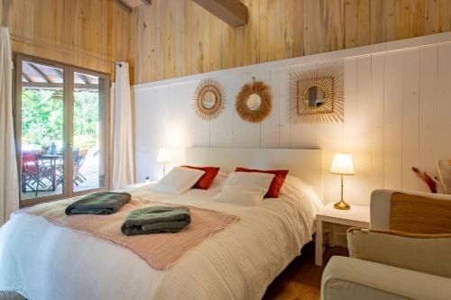 a bedroom with a bed with two pillows on it at Magnifique Villa avec jacuzzi les 44Hectares in Cap-Ferret