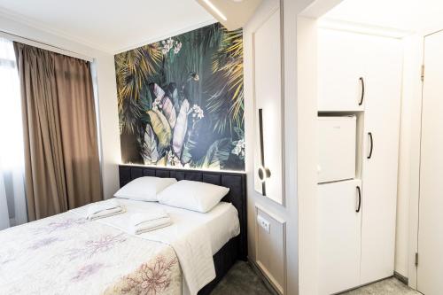 a bedroom with a bed and a painting on the wall at Garni Hotel Lotos in Niš