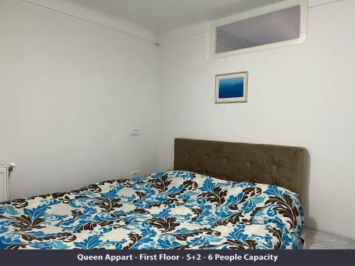 a bedroom with a bed with a blue and white blanket at Tunisia Queen Apartment in Hammamet