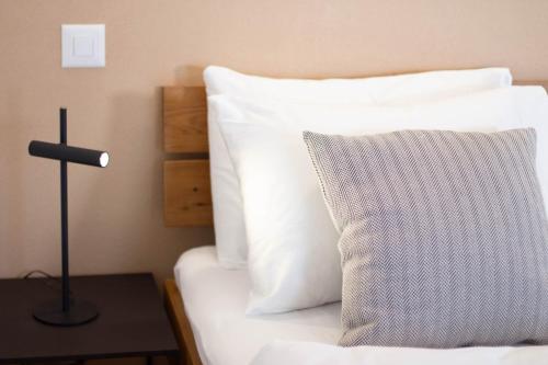 a bed with a pillow and a lamp on a table at Osteria Bäkar in Villa