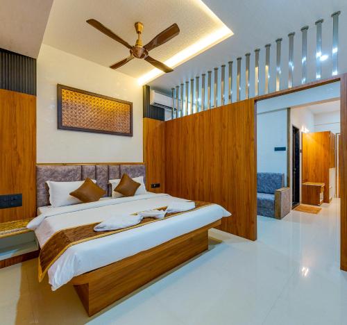 a bedroom with a large bed and a ceiling fan at Hotel Blooming Soul in Kolhapur