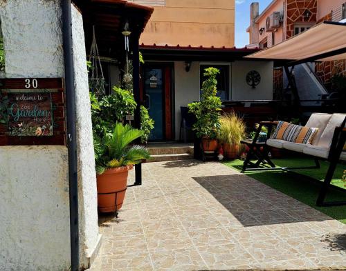 a patio with potted plants in front of a building at Zoe garden home in Spáta