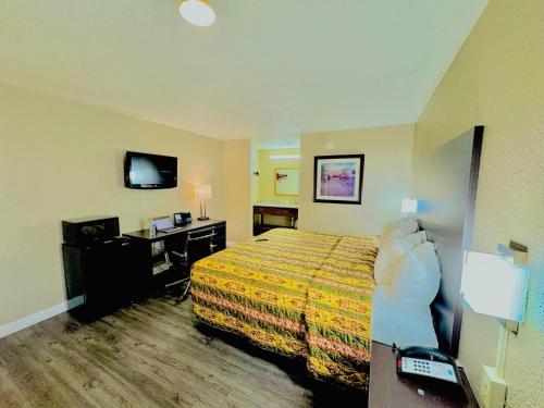 a hotel room with a bed and a desk at Rodeway Inn Expo Center in Spartanburg