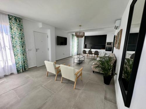 Una sala de estar con un sofá y sillas y una mesa. en Apartamentos Muñoz Fornell 2, en Chiclana de la Frontera