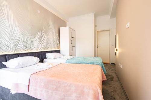 a hotel room with two beds in a room at Garni Hotel Lotos in Niš