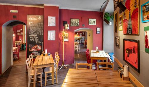 a restaurant with wooden tables and chairs and red walls at Hotel "Palác U Kočků" by Adrez, Palace At the Cats in Prague
