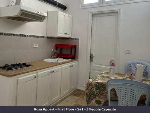 a kitchen with a sink and a table with chairs at Tunisia Queen Apartment in Hammamet