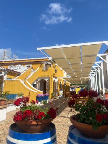 サン・ニコーラ・アルチェッラにあるOriente Camereの建物前の鉢植えの花のパティオ