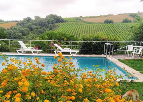 a swimming pool with two chairs and a table and chairs at Quinta Santo António in Pereiro da Palhacana