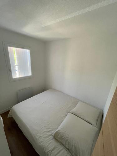 Cette petite chambre blanche comprend un lit. dans l'établissement Appartement plage du cap Rousset carry le rouet 1 chambre 6 couchages, à Carry-le-Rouet