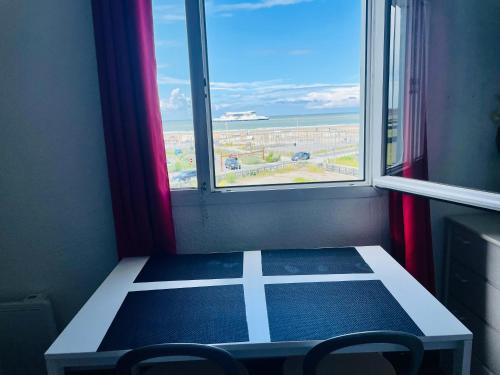 a room with a table and two chairs and a window at Au rythme des Ferrys in Calais