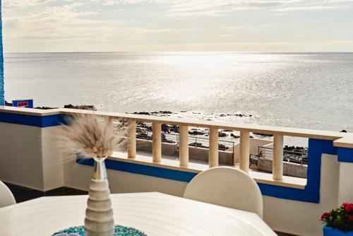 a balcony with a table and chairs and the ocean at B&B AcquaDolce in Cala Gonone