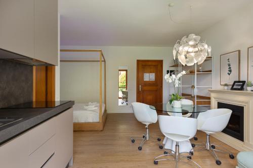 a kitchen with a glass table and white chairs at Appartamento Marina in Stresa