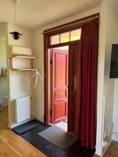 an open door with a red curtain in a room at Björnnästet med havsutsikt innanför murarna in Visby