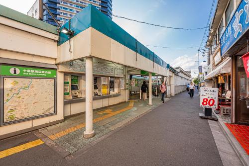 een straat met winkels en mensen die op de stoep lopen bij W Hostel in Tokyo