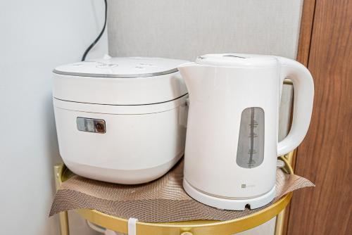 dwa białe ekspresy do kawy stojące na krześle w obiekcie W Hostel w Tokio