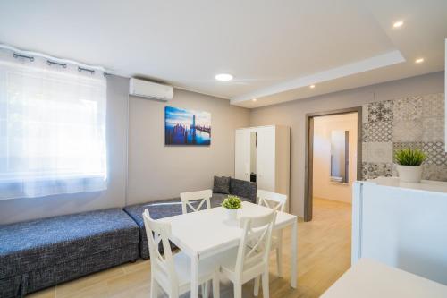 a living room with a white table and a couch at Riviéra Apartmanház in Siófok
