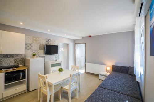 a kitchen and living room with a table and chairs at Riviéra Apartmanház in Siófok