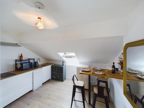 une cuisine avec une table et des chaises dans une pièce dans l'établissement Appartement typique bord de mer, à Algajola