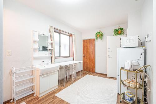 eine Küche mit Spüle und Kühlschrank in der Unterkunft W Hostel in Tokio