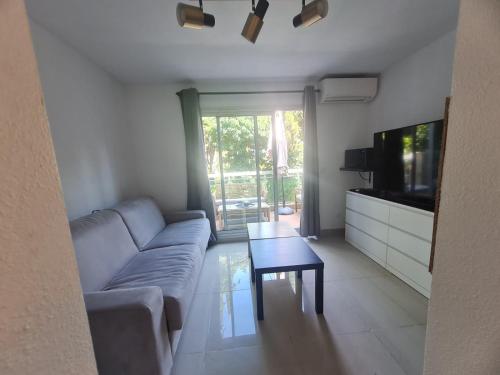 un salon avec un canapé, une télévision et une table dans l'établissement Studio Cabine Golfe Marine, à Vallauris