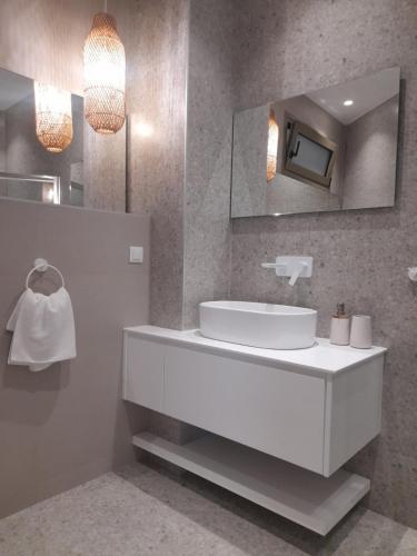 a bathroom with a white sink and a mirror at Kosmos Retreat in Kos