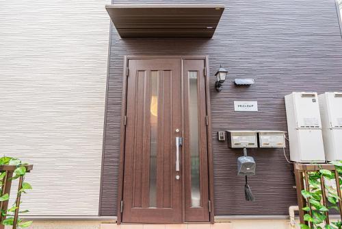una puerta de madera en el costado de un edificio en W Hostel, en Tokio