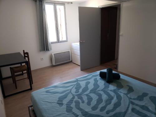 a bedroom with a bed and a desk and a window at Chambres meublées et spacieuses in LʼIsle-Jourdain