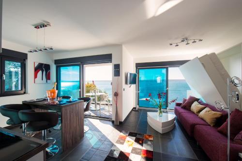 a living room with a purple couch and a table at Design-Beachresort - with Pool - first line to the sea in Maslenica
