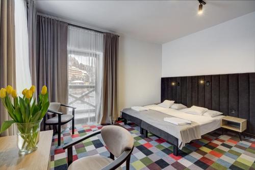 a hotel room with a bed and a table and chairs at OSW Pan Tadeusz in Krynica Zdrój