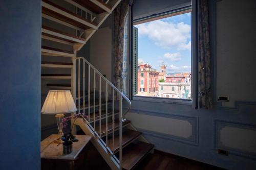a staircase with a window and a lamp on a table at Suite Hotel Nettuno in Sestri Levante