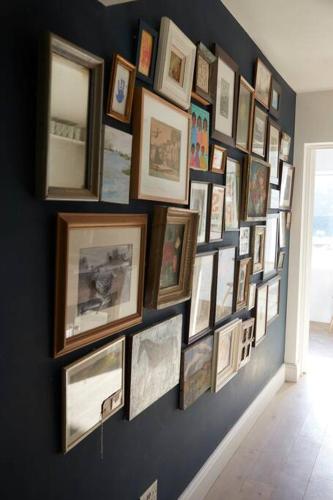 a wall filled with framed pictures on a wall at The Skyroom in Rendham