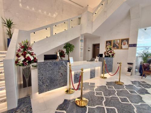 a lobby with a staircase and flowers on display at فندق مادن طيبة MADEN Taiba HOTEL in Al Madinah
