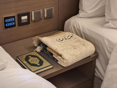 a hotel room with two beds and a blanket on a table at فندق مادن طيبة MADEN Taiba HOTEL in Al Madinah