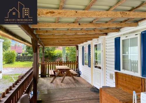 une pergola sur le porche d'une petite maison dans l'établissement Spacieux mobil home - Terrasse, à Verchaix