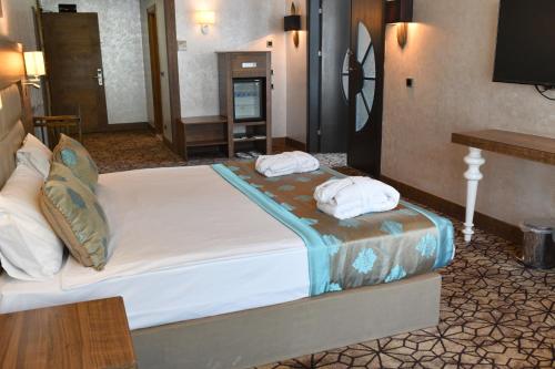 a bedroom with a large bed with towels on it at Royal Hotel Inegol in Inegol