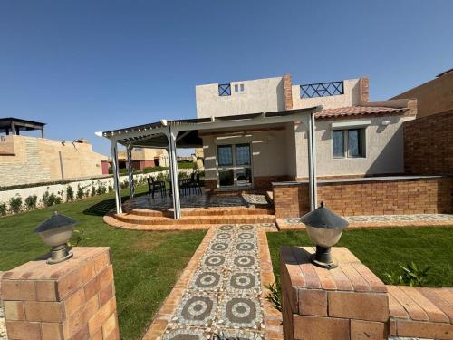 a house with a patio in the yard at On the beach house in El Hamam