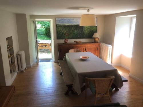 une salle à manger avec une table et un tableau au mur dans l'établissement Sabatou, le cottage Cévenol, à Florac Trois Riviere