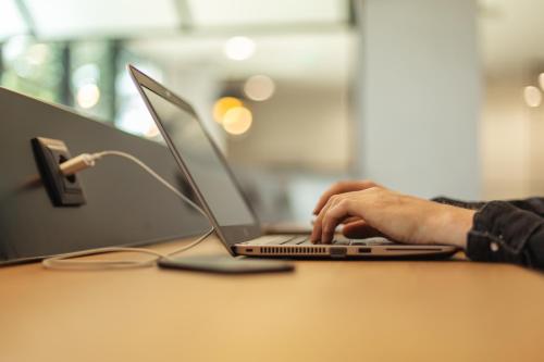 a person typing on a laptop computer on a table at Holiday Inn - the niu, Cure Erlangen by IHG in Erlangen