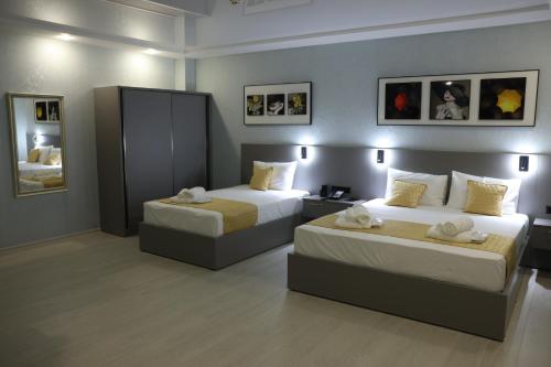 a hotel room with two beds and pictures on the wall at OLD BaTuMi in Batumi