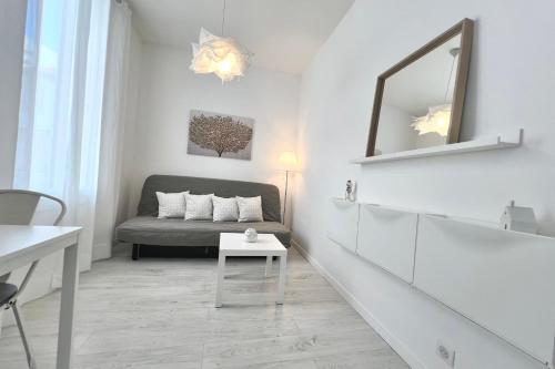 Cette chambre blanche comprend un lit et un miroir. dans l'établissement Juan les Pins Pinède sector - Apartment 4 People, à Juan-les-Pins