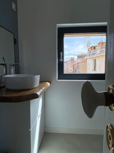 une salle de bain avec un lavabo et une fenêtre dans l'établissement T2 apartment historic center Ajaccio, à Ajaccio