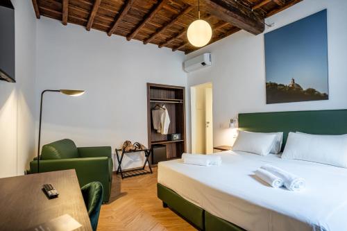 een slaapkamer met een groot bed en een groene stoel bij Fantini Rooms-Monti in Rome
